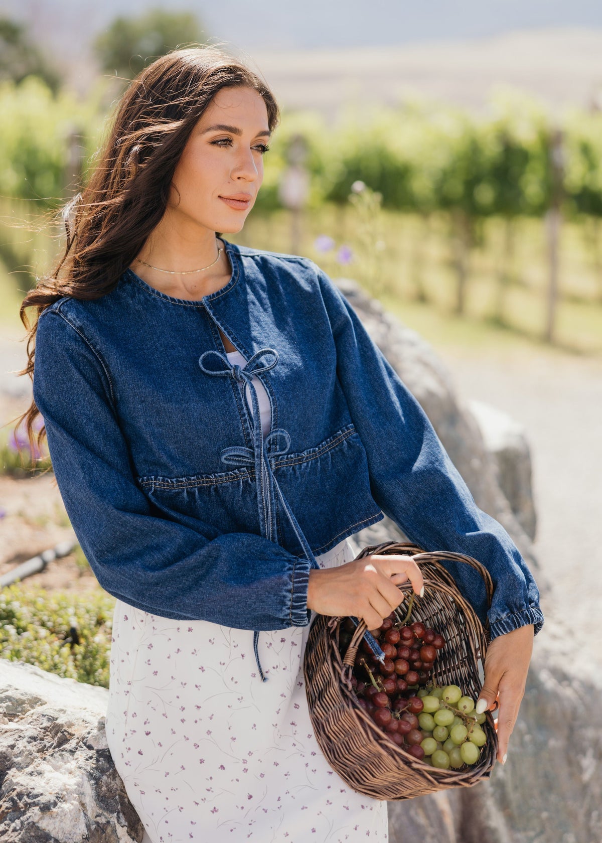 Woman holding a basket of grapes in a vineyard
